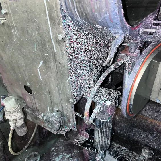 Close-up of dry ice blasting removing ink buildup on machine